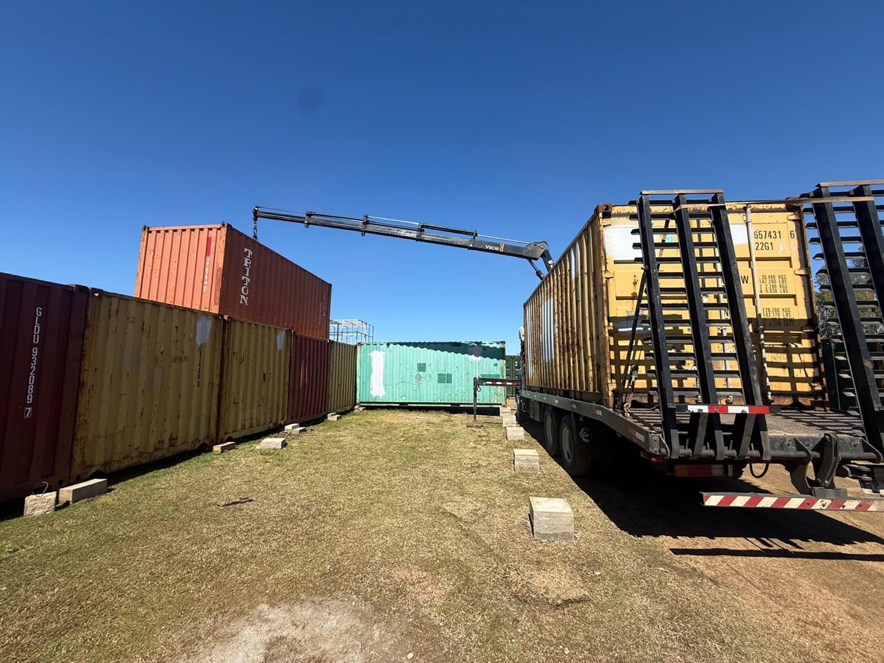 Semirremolque cargado junto a contenedores en la base